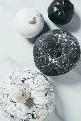 top view of decorative halloween black and white pumpkins with paint splatters