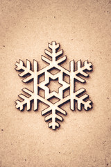 Wooden snowflake on craft paper