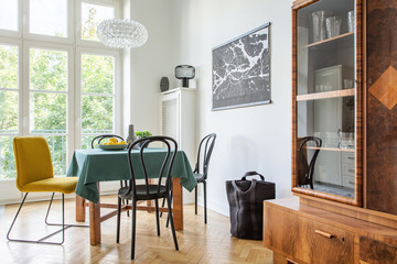 Retro dining room interior with a table, chairs and cupboard in a tenement house