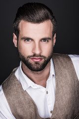 Obraz premium portrait of confident bearded man looking at camera, isolated on grey