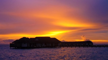 Amazing sunset with seascape and water villas in Maldives.