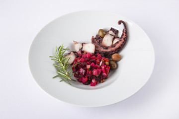 Salad from beet and octopus. Vinegret is a traditional Russian salad made from beets and vegetables. The background is white. Copy space. Horizontal shot.