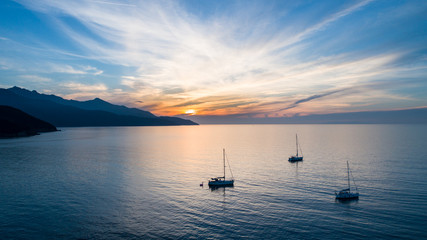 Naklejka na ściany i meble Sailboats in the sea at sunset, beautiful scene
