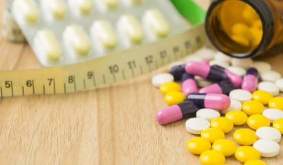 medicines and waist circumference in closeup view with some spac