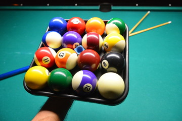 Ball-Set mit Kreide auf Kunststoff-Tablett in der Hand des Spielers am Billard-Tisch