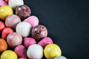colorful balls of chewing gum on a black background