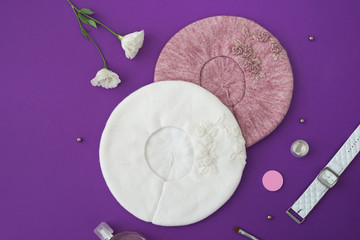 Knitted hats with decor on lilac background