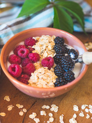 Smoothie yogurt bowl with oats and berries on wooden rustic board. Healthy eating breakfast