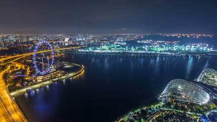Skyline of Singapore with famous Singapore Ferries Wheel night timelapse