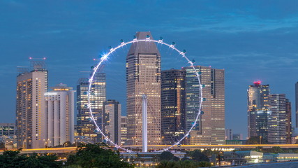 Skyline of Singapore with famous Singapore Ferries Wheel night to day timelapse