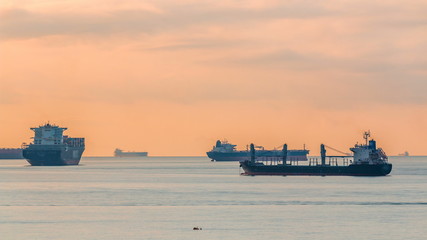 Early morning scene of cargo ships and tankers anchored off of Singapore's coast timelapse