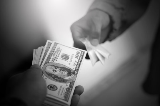 Concept: the Asian men are buying-selling drugs with dollars."International Day against Drug Abuse and Illicit Trafficking"
