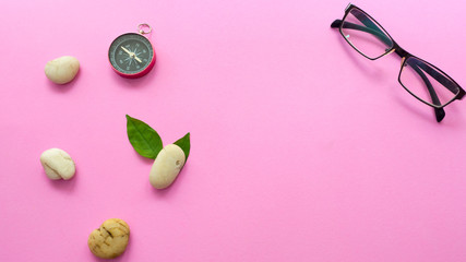White rock stone and compass with glass on pink background.modern zen concept