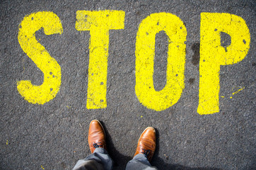 stop sign on the ground  in front of feets