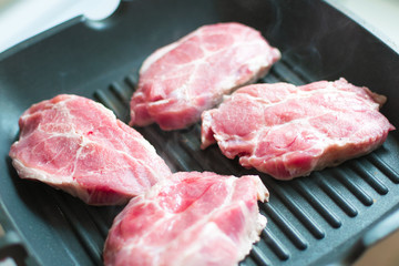 Raw meat in a frying pan.