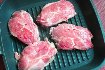 Raw meat in a frying pan.