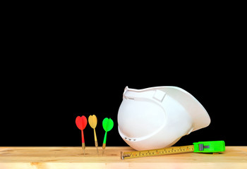 helmet plastic white supine with three dart. hat safety equipment working of engineering concept construction on Wooden floor isolated black background clipping path