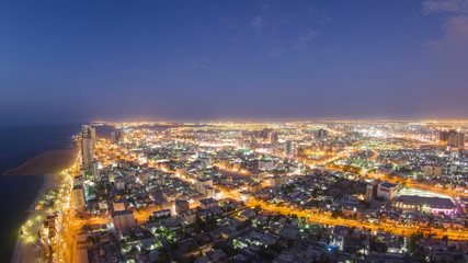 Fototapeta na wymiar Cityscape of Ajman from rooftop day to night timelapse. Ajman is the capital of the emirate of Ajman in the United Arab Emirates.