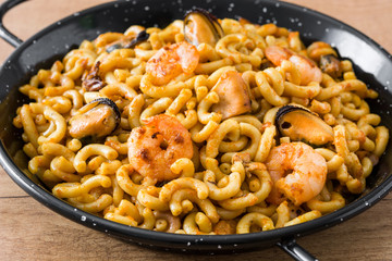 Traditional Spanish fideua. Noodle paella on wooden table