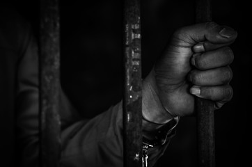 The men were arrested, handcuffed prisoner in jail with dark lighting