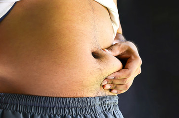 Naklejka premium Belly fat man with a soft-focus background is dark.