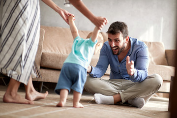 Fototapeta premium happy family mother and father playing with a baby at home.