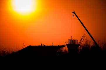 Fototapeta na wymiar Silhouette crane with building Sunset light