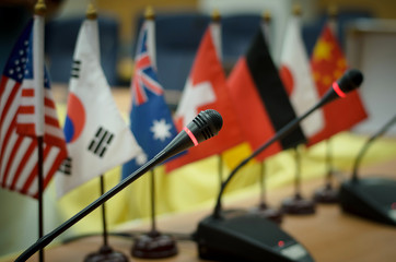Microphone in a conference room, with flags of various countries