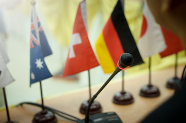 Microphone in a conference room, with flags of various countries