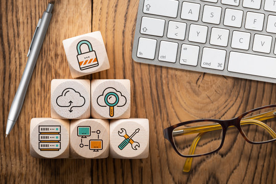 Symbole für Cloud Services auf Würfeln am Arbeitsplatz