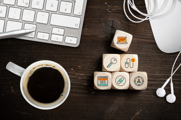 Online-Marketing Komponenten als Symbole auf Würfeln am Arbeitsplatz