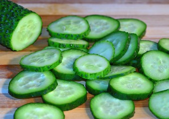 Cucumber sliced with circles lies on a wooden board, cooking, healthy food and vitamins