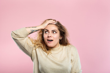 surprised astonished overwhelmed girl. young beautiful woman with   hair on pink background. emotional facial expression and reaction concept.