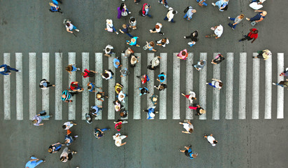 Aerial. Pedestrians passing a crosswalk. Rush hour in the city. People are rushing to work. - obrazy, fototapety, plakaty