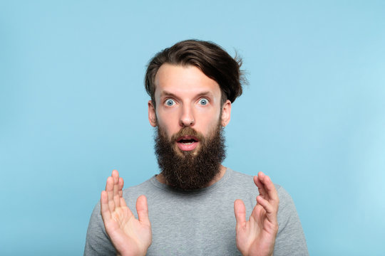 Omg Unbelievable Shock Amazement. Dumbfounded Man With Open Mouth. Portrait Of A Young Bearded Guy On Blue Background. Emotion Facial Expression And Reaction Concept.