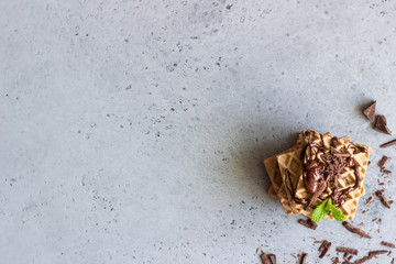 Chocolate waffles with chocolate cream sprinkles chocolate topping and decorated pieces of chocolate and fresh mint.