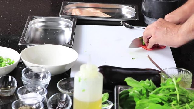 chef cutting colorful vegetables on cutting board
