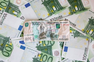 Crumpled banknote of one thousand rubles against the background of hundreds euro banknotes