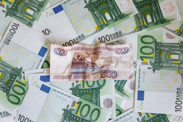 Crumpled banknote of five hundred rubles against the background of hundreds euro banknotes