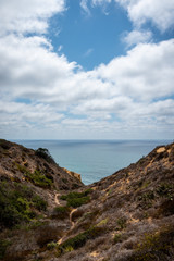 Fototapeta na wymiar Hiking trail descends to the ocean through rugged terrain.