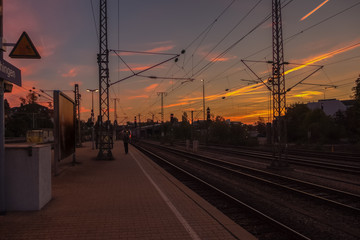 Fototapeta na wymiar A colorful sunrise above the train station of a German city