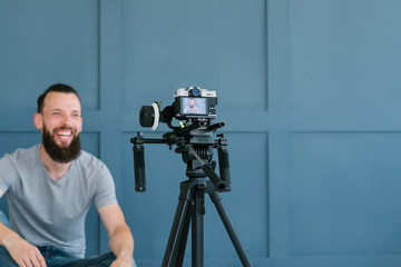 content creation for social media. bearded man shooting video of himself using camera on tripod....