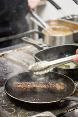 A chef prepares a fried beef gourmet dinner.