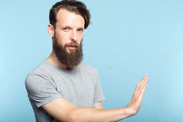 young man rejecting virtual object with hand or touching it with palm. copy space for advertisement...