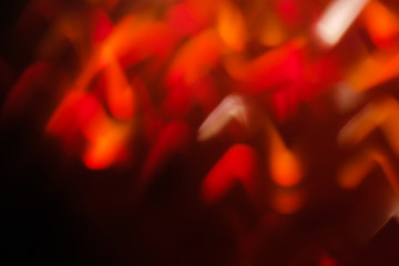 abstract lens flare on black background. red defocused bokeh lights. blurred new year wallpaper decor. illuminated glowing waves of sparkle design.