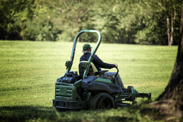 lawn mower tractor working in the town park