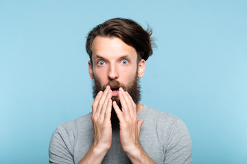 omg unbelievable shock amazement. astounded man with open mouth. portrait of a young bearded guy on blue background. emotion facial expression and reaction concept. - obrazy, fototapety, plakaty