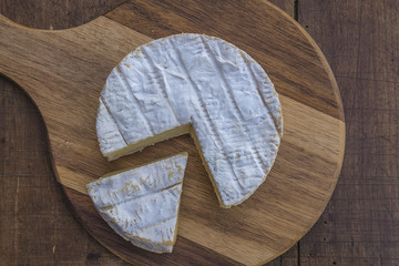 French goat cheese slice top view on wooden cutting board