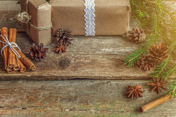 Obraz premium Christmas New Year composition with gift box fir branch pine cones cinnamon sticks on old shabby rustic wooden background. Xmas holiday december decoration to Russian tradition. Flat lay, copy space