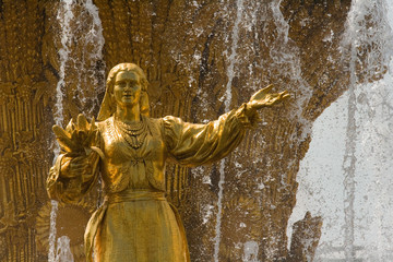 Beautiful golden statue of the fountain "Friendship of Nations" (Druzhba narodov VDNKH) – a Beautiful Soviet sculpture in Moscow (Russia)